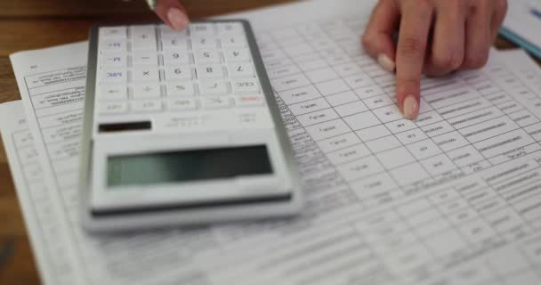 Бухгалтерия на калькуляторе и финансовый отчет в офисе на рабочем месте. Концепция бухгалтерского учета, финансов и экономики - Кадры, видео