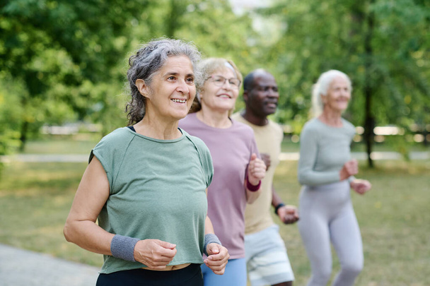 Gruppo di anziani che fanno jogging insieme nel parco all'aperto - Foto, immagini