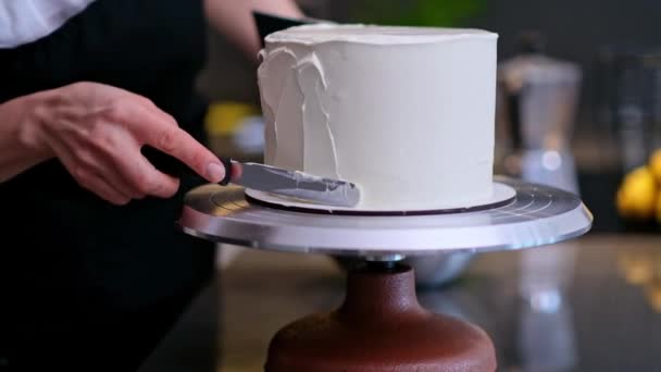 Becerikli bir pastacı, arka planda bulanık bıçaklı beyaz mastikte geleneksel düğün kutlaması için ev yapımı pasta hazırlıyor. - Video, Çekim