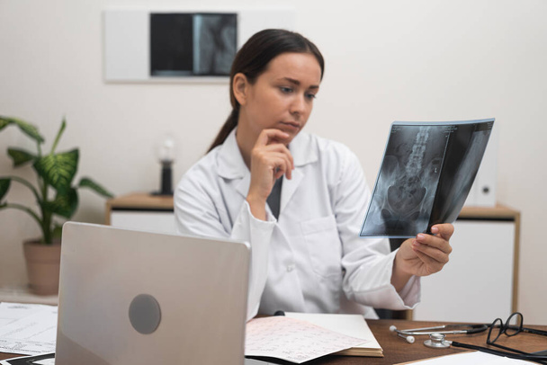 лікар з використанням радіологічної рентгенівської плівки для діагностики хвороби пацієнтів у рамках медичних послуг у лікарні. - Фото, зображення