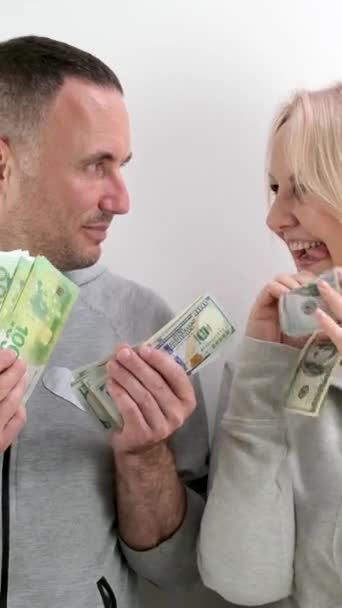 Keski-ikäinen vaimo pyytää mieheltään rahaa ostaa dollareita ja euroja, aviomies osallistuu siihen, vaimo murjottaa huuliaan, piilottaa rahaa rintaansa, nauraa, hymyilee, flirttailee, aviomies piilotti dollareita - Materiaali, video