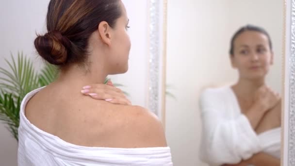 Shoulder TLC: In her bathroom, she caresses her shoulder with moisturizing cream, immersing herself in a soothing body care spa at home. - Кадры, видео