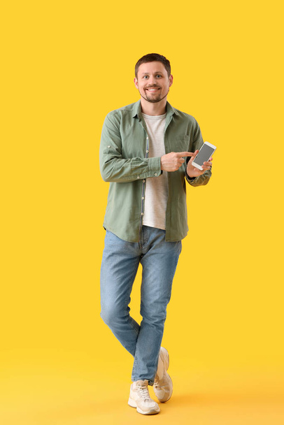 Hombre con smartphone sobre fondo amarillo - Foto, imagen