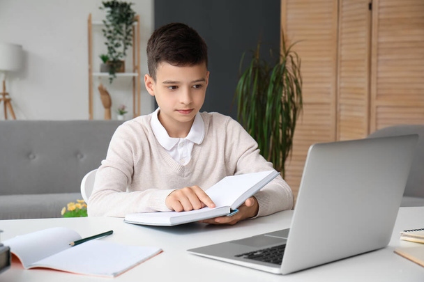 Kleiner Junge mit Buch lernt zu Hause online - Foto, Bild