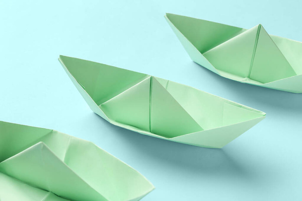 Green origami boats on blue background - Photo, Image