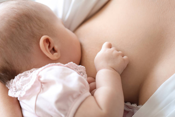 Молода жінка грудного вигодовування дитини вдома, крупним планом
 - Фото, зображення