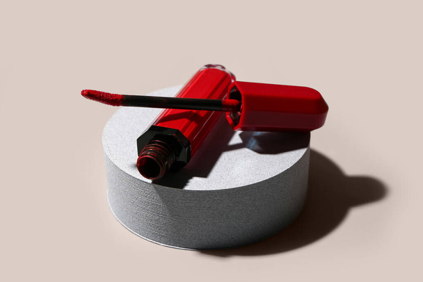 Soporte con elegante lápiz labial rojo con pincel sobre fondo claro, primer plano - Foto, imagen
