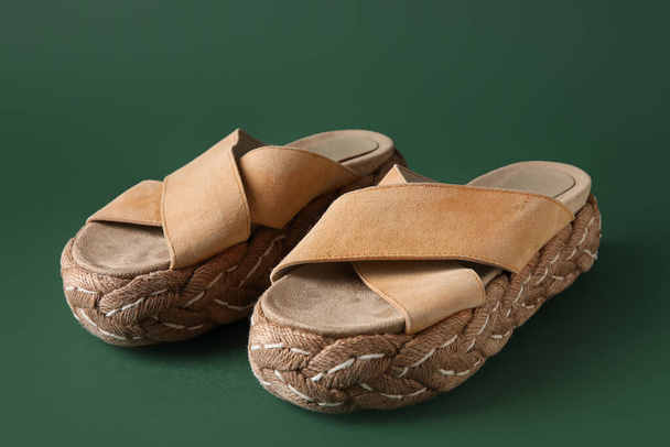 Stylish beige sandals on green background - Photo, Image