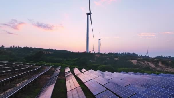 sunset view of solar energy panels and wind turbines in the countryside, renewable energy source - Footage, Video