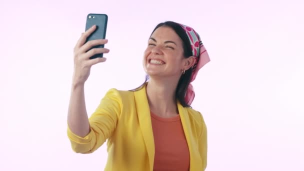 Selfie, εικόνα προφίλ και σημάδι ειρήνης με μια γυναίκα influencer στο στούντιο σε ένα μπλε φόντο για μια ενημερωμένη κατάσταση. Τηλέφωνο, χαμόγελο και φωτογραφία με έναν ευτυχισμένο δημιουργό περιεχομένου που ποζάρει για τα social media. - Πλάνα, βίντεο