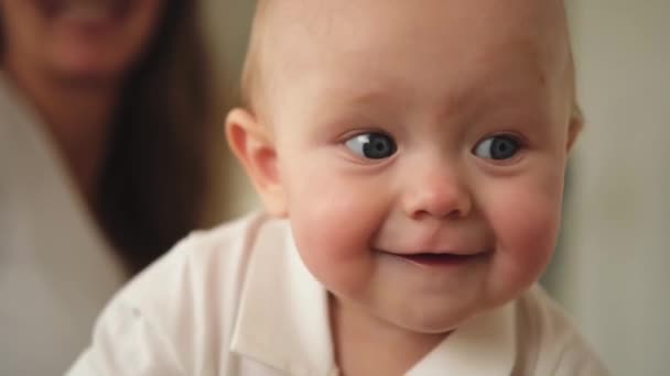 Happy baby. Cute little newborn girl with smiling face crawling on couch in bedroom. Emotional infant baby smiling resting playing on sofa at home. Motherhood happy child childcare concept - Footage, Video