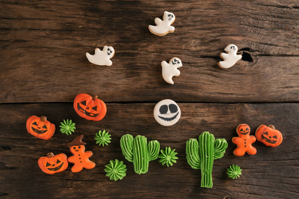 Halloween homemade gingerbread cookies on wooden table. Sweets for delicious treat and Halloween party - Photo, Image