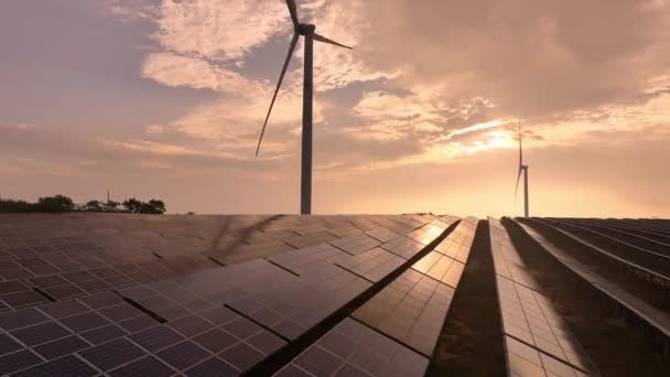 Zonsondergang vanuit de lucht van zonnepanelen en windturbines op het platteland, hernieuwbare energiebronnen - Video