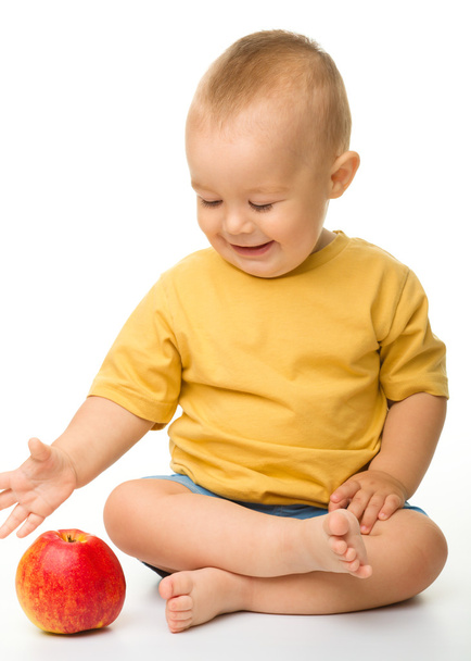 Cheerful little boy with red apple - Fotografie, Obrázek