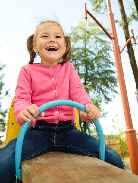 Cute little girl is swinging on see-saw - Photo, Image