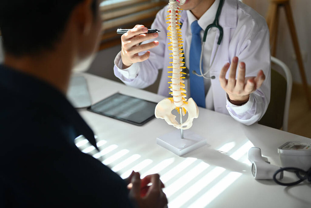 Ortopedi antaa neuvoja skolioosista tai selkärangan ongelmista potilaalle lääkärintarkastuksen aikana. Terveydenhuollon käsite. - Valokuva, kuva