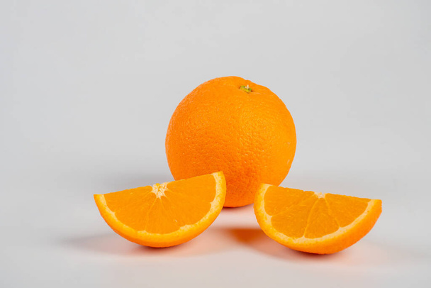 Aislar rebanadas de naranja. Mitad de fruta naranja y rebanada sobre fondo blanco. - Foto, imagen