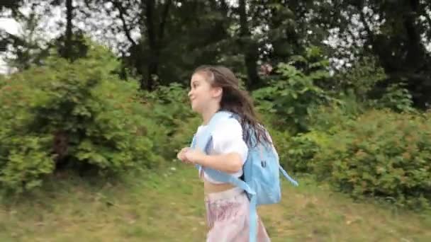 Menina confiante com uma mochila correndo para a escola pela manhã. Aprendizagem na escola. - Filmagem, Vídeo