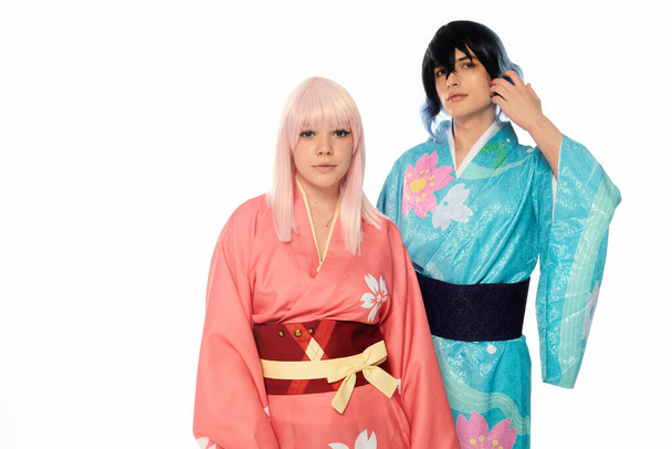 młoda para cosplay w kolorowe kimony i peruki patrząc w aparat na białym, poziomym banerze - Zdjęcie, obraz