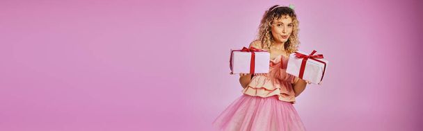 krásná blondýnka žena v zubní víla kostým představení dárky na kameře na růžovém pozadí, banner - Fotografie, Obrázek