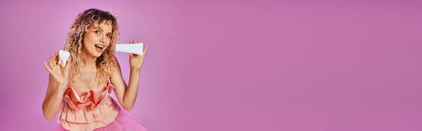 радостная красивая зубная фея в розовом костюме и ободке с зубной пастой и молочным зубом, баннер - Фото, изображение