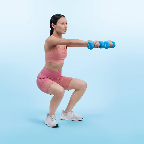 隔離された背景で運動を持ち上げるダンベル重量を行っている活発な女性. ボディワークアウトルーチンとしての若い運動アジアの女性の強さと耐久トレーニングセッション. - 写真・画像