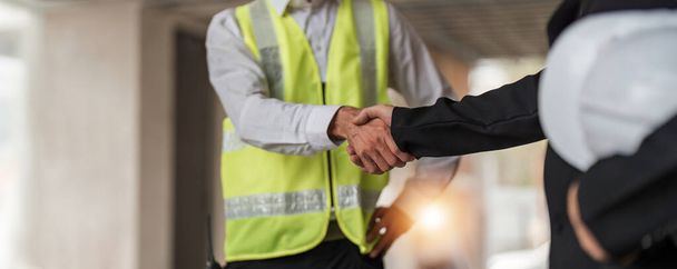 Hand in hand between project contractors and customers due to negotiation of expenses and investments, construction and repair of residential buildings.. - Fotoğraf, Görsel