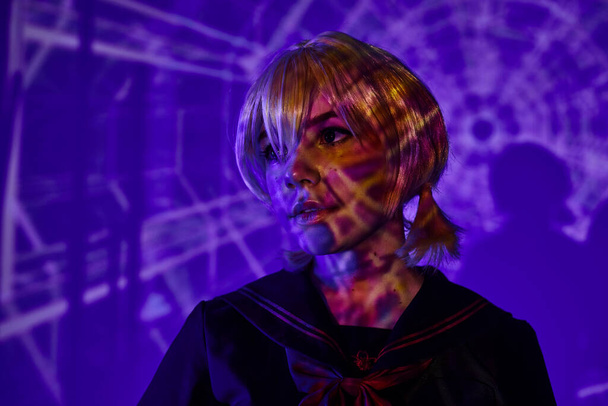 portrait of anime woman in blonde wig in abstract projection on blue neon backdrop, fusion style - Photo, Image