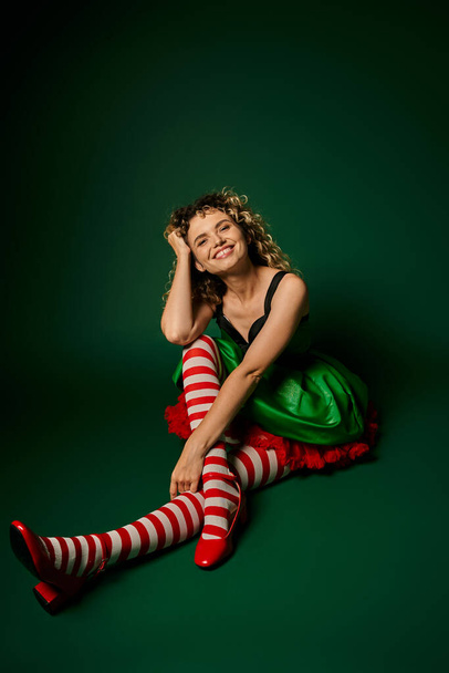 felice donna in abito festivo con calze a righe sorridente alla macchina fotografica, nuovo concetto elfo anno - Foto, immagini
