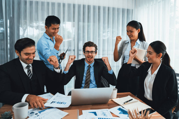 Boldog üzletemberek csoportja ünnepi gesztussal és sikeres csapatmunkával. Különböző faji irodai dolgozók ünnepelnek, miután előrehaladást értek el a marketing tervezésben a vállalati irodában. Megszokás - Fotó, kép