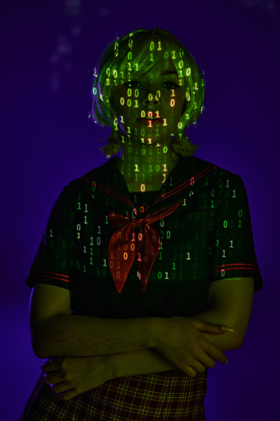 young female student in neon programming code projection on blue backdrop, cosplay character - Photo, Image