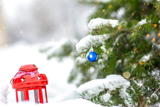 Rote Laterne im Schnee an Heiligabend. Winter-Hintergrund. Neujahrsstimmung in Vorbereitung auf die Feiertage. - Foto, Bild
