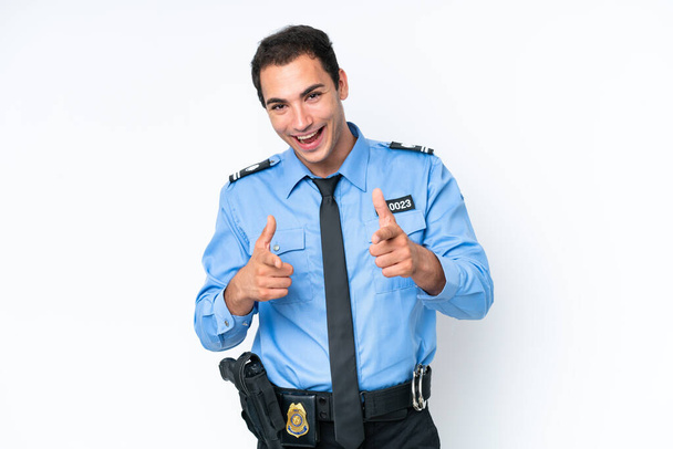 Молодий поліцейський кавказький чоловік ізольований на білому тлі, вказуючи на фронт і посміхаючись
 - Фото, зображення