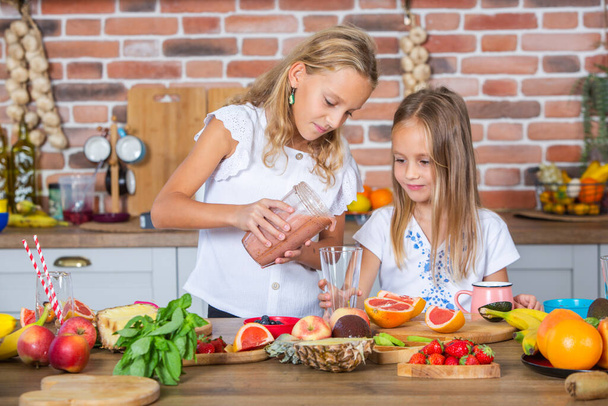 Két kislány a konyhában friss zöldségekkel. Egészséges étel koncepció. Boldog nővérek.. - Fotó, kép