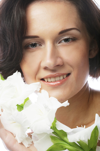 woman with gladiolus flowers in her hands - Fotó, kép