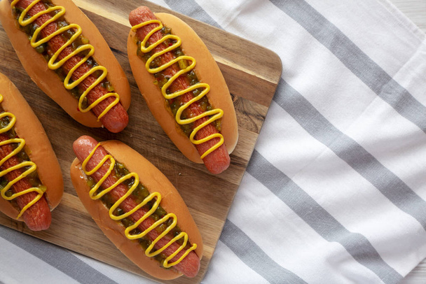 Hot-dogs gastronomiques faits maison avec des reliques sucrées et de la moutarde, vue de dessus. Couché à plat, au-dessus, par le haut. Espace de copie. - Photo, image