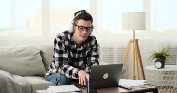 Balancing the joy of music with academic responsibilities, a content student listens to tunes while engaging in homework. Their smile reflects the harmonious blend of productivity. - Footage, Video
