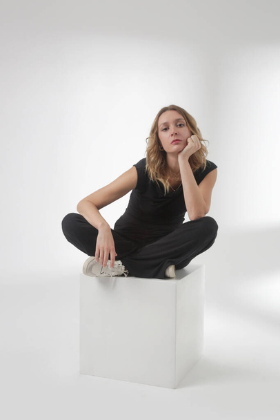 Serie of studio photos of young female model wearing comfortable basic black outfit, sleeveless shirt and wide leg pants, cozy loungewear set made from organic cotton - Φωτογραφία, εικόνα