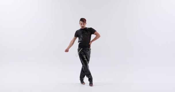 An active and vibrant individual of Caucasian descent unleashes their dance moves on a clean white background. Their spirited performance exudes boundless energy and enthusiasm. - Footage, Video