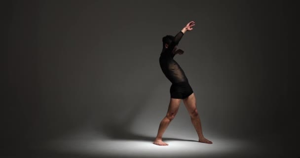 Een doorgewinterde professionele danser toont zijn uitzonderlijke vaardigheden met finesse tegen een ingetogen grijze achtergrond. Hun performance straalt meesterschap uit en creëert een visueel boeiende danservaring. - Video