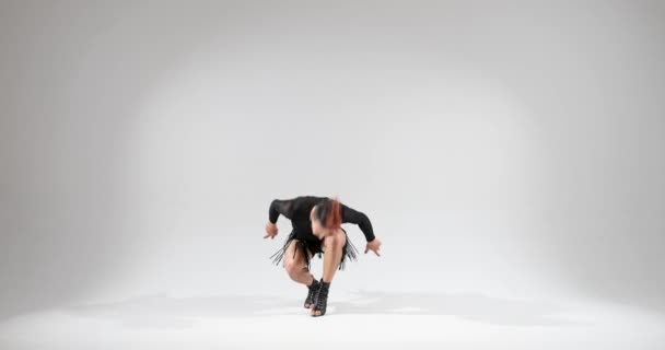 男は自信を持って白い背景にスタジオの設定でスカートを着用しながらダンスのスキルを披露します. 彼の芸術的でスタイリッシュな動きは視覚的に魅力的でユニークなパフォーマンスを作成します. - 映像、動画