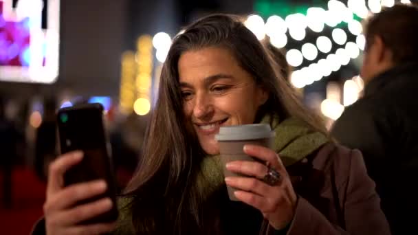 boldog nő csinál szelfi mobiltelefonnal éjjel város - Felvétel, videó