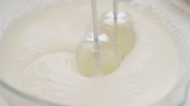 Close-up of a professional mixer with two beaters beating a dough in a bowl on a white table - Footage, Video