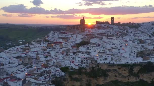 Henkeäsalpaava drone näkymä valkoiset talot Arcos de la Frontera kaupunki sijaitsee kalliolla vastaan pilvinen auringonlasku taivas Andalusiassa, Espanja - Materiaali, video