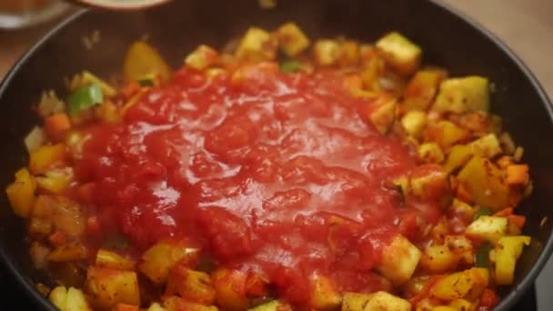 De dessus de cuisinier méconnaissable en ajoutant des haricots blancs en conserve dans une casserole avec cuisson des légumes et de la tomate cause tout en préparant le gratin dans la cuisine - Séquence, vidéo