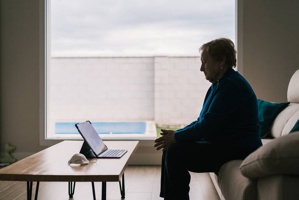 Γριά γυναίκα επικοινωνεί με την κόρη της σε βίντεο chat στο φορητό υπολογιστή - Φωτογραφία, εικόνα