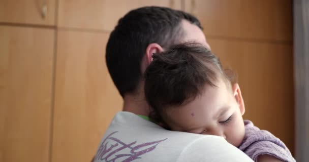 un pequeño bebé se durmió en los brazos de sus padres. Papá meciendo al bebé para dormir en casa. primer plano. - Imágenes, Vídeo