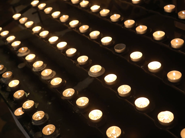 acendeu velas votivas com a chama por peregrinos durante o culto religioso dentro da igreja - Foto, Imagem