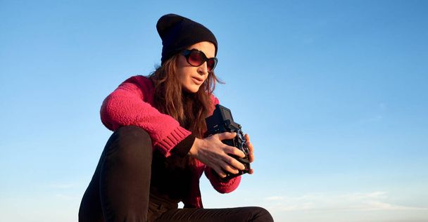 Nainen valokuvaaja ottaa kuvia vintage 6x6 kamera sinisen taivaan alla, panoraamanäköalalla. Kopioi tilaa. - Valokuva, kuva