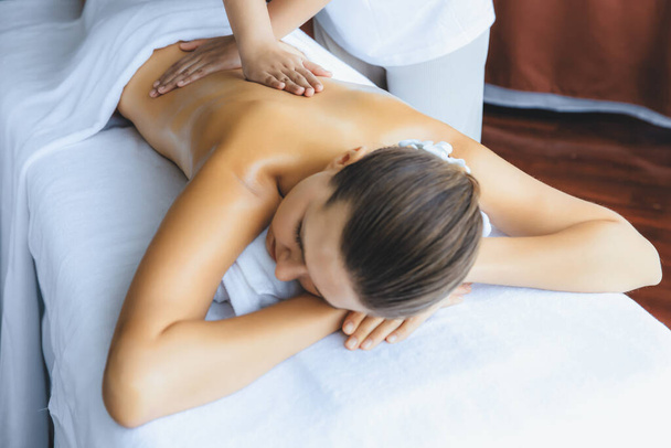 Кавказька жінка-клієнт насолоджується розслабляючим антистресовим спа-масажем і бродить з дозвіллям краси шкіри відпочинку в денному світлому навколишньому салоні спа в розкішному курорті або готелі. Тихіше - Фото, зображення